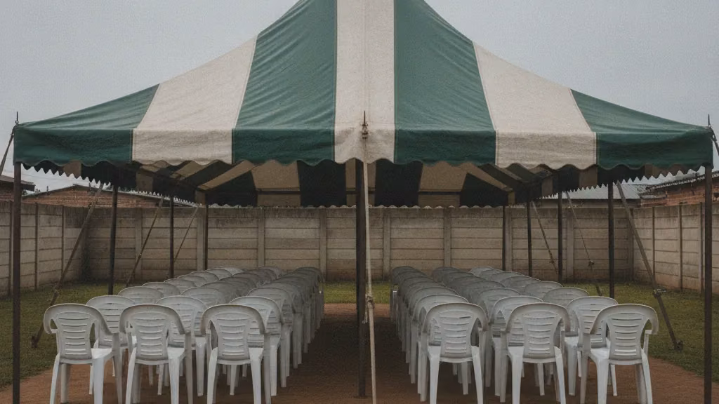 Green and white striped funeral tent with rows of white plastic chairs in a Durban yard